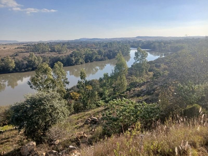A scenic elevated view overlooking a winding river surrounded by natural vegetation and rolling hills.