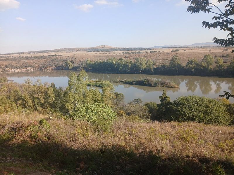 A scenic view overlooking a river and natural landscape, showcasing the tranquil surroundings of the vacant land.