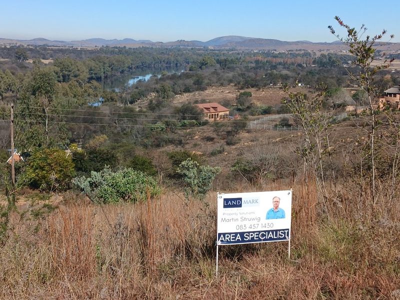 A scenic elevated view overlooking a natural landscape with a river, showcasing the surrounding terrain and vegetation.