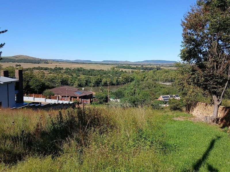 A scenic elevated view overlooking a natural landscape, river, and surrounding residential properties.