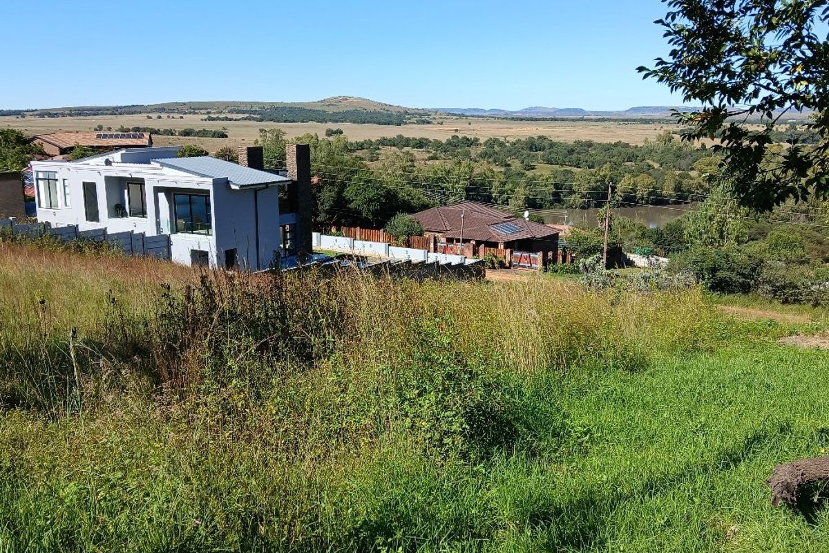 An elevated view overlooking the surrounding landscape and neighboring residential properties, showcasing the scenic location of the vacant land.