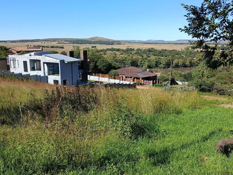 An elevated view overlooking the surrounding landscape and neighboring residential properties, showcasing the scenic location of the vacant land.