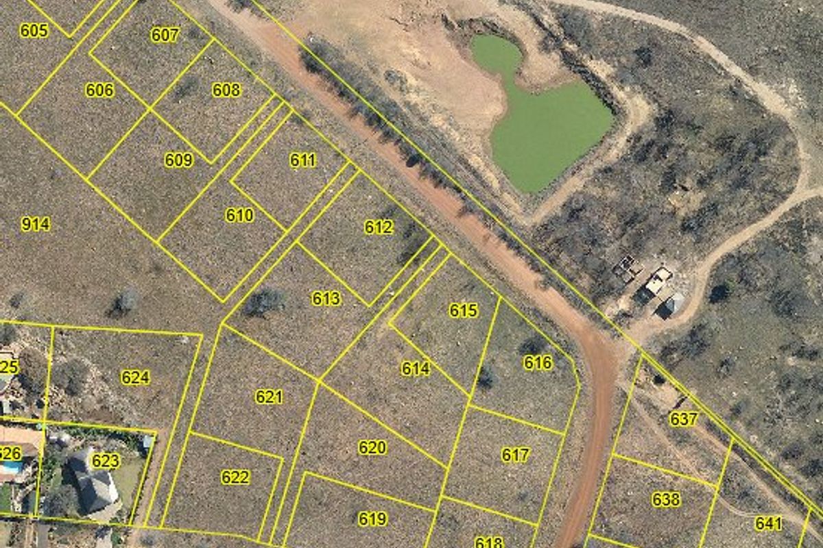 An aerial view showing the layout of vacant residential land parcels, including access roads and a natural pond feature.