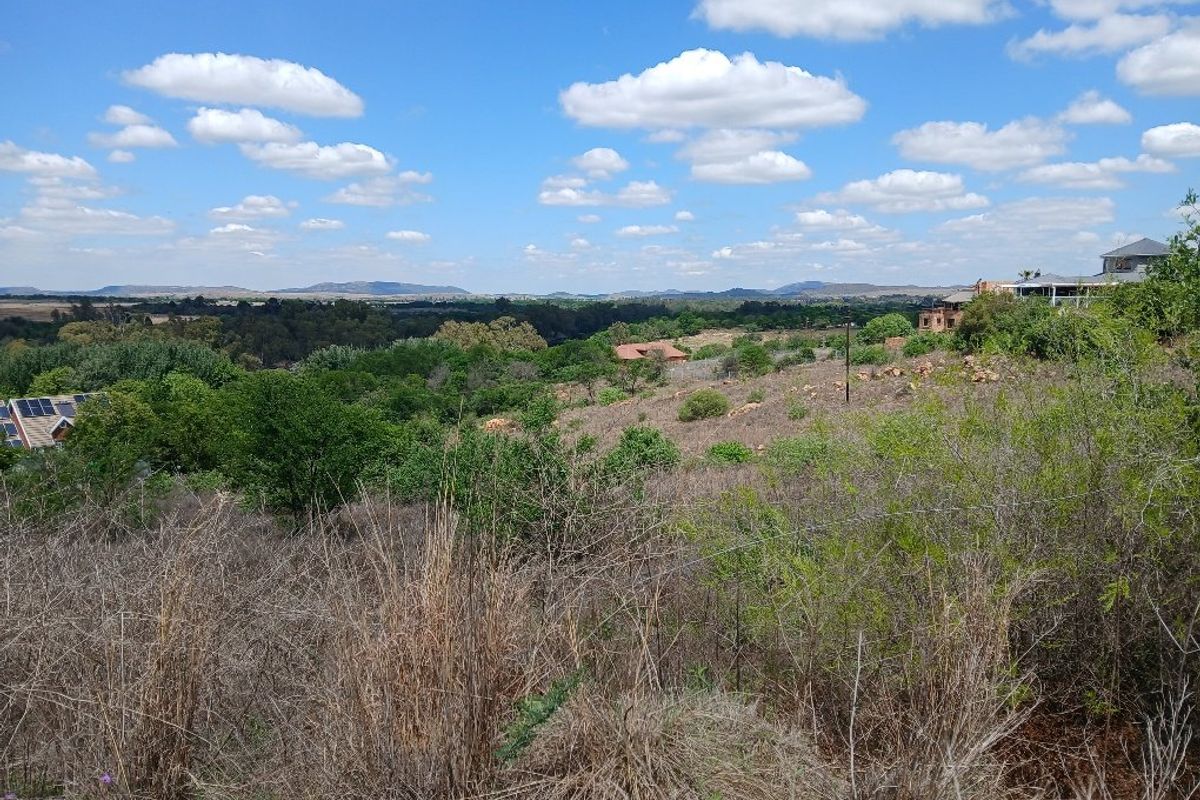 A wide-angle view of the surrounding natural landscape and rolling hills, showcasing the expansive outlook from the vacant residential land.