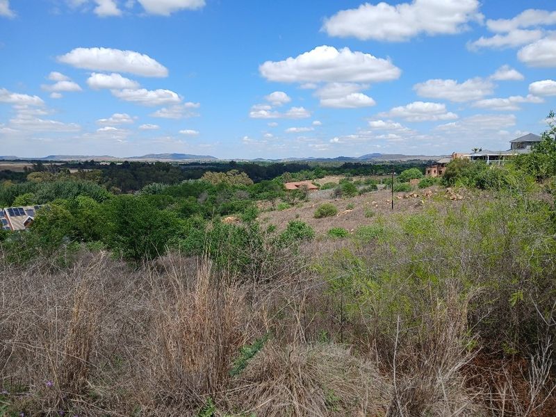 A wide-angle view of the surrounding natural landscape and rolling hills, showcasing the expansive outlook from the vacant residential land.