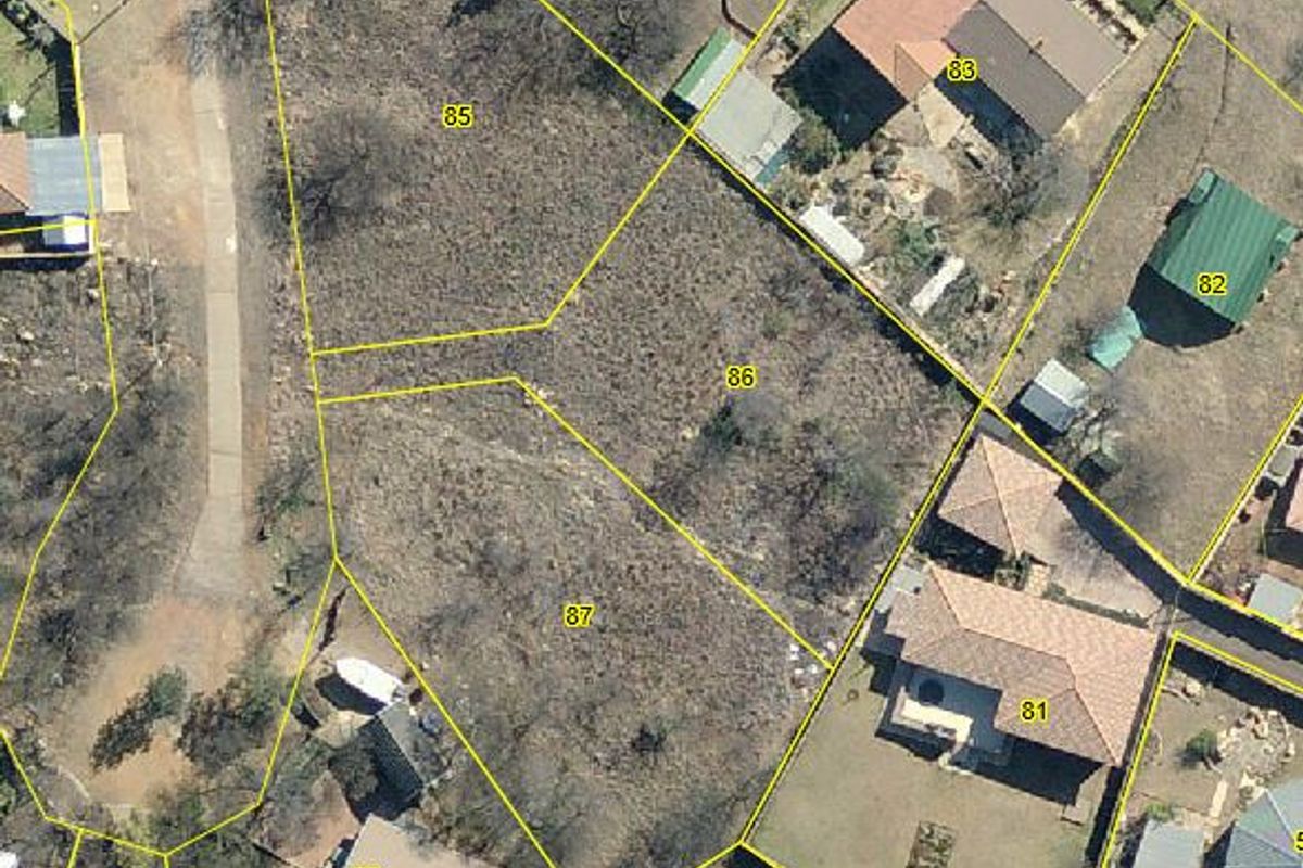 An aerial view of vacant residential land plots, showing the site boundaries and surrounding neighborhood context.