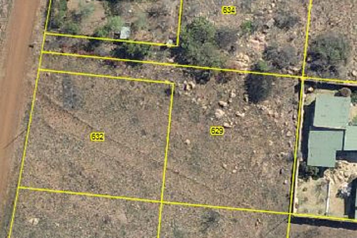Aerial view of vacant residential land plots with marked boundaries in a natural, undeveloped setting.