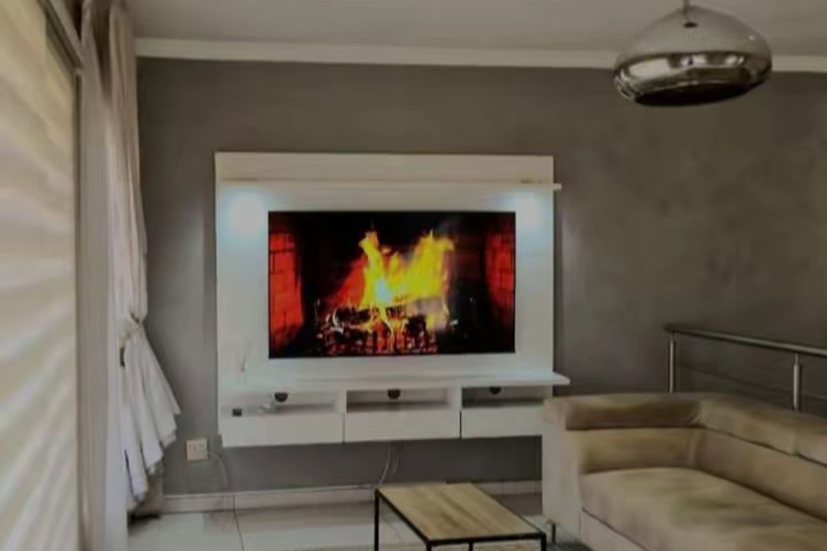 Modern living room featuring a built-in fireplace with integrated media console, recessed lighting, and sleek tiled flooring.