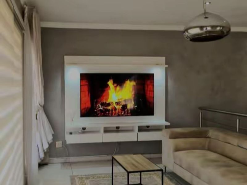Modern living room featuring a built-in fireplace with integrated media console, recessed lighting, and sleek tiled flooring.