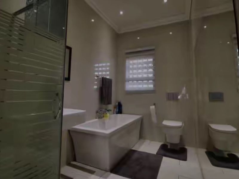 Modern bathroom featuring a freestanding bathtub, wall-mounted toilet, and a glass-enclosed shower with contemporary tiled finishes and recessed lighting.