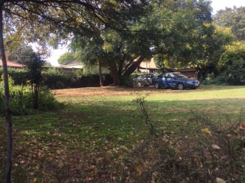 A spacious, tree-lined garden area with established lawn and mature trees, offering a private outdoor space.