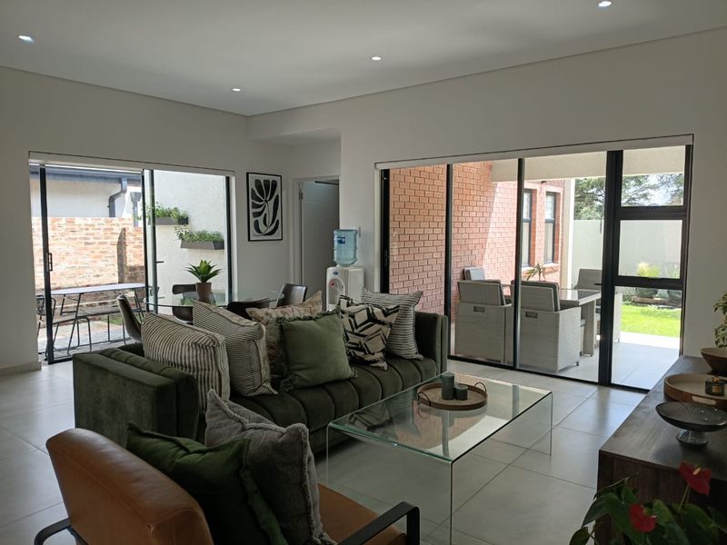 Spacious open-plan living area featuring large sliding glass doors that provide seamless access to the outdoor patio and garden spaces.