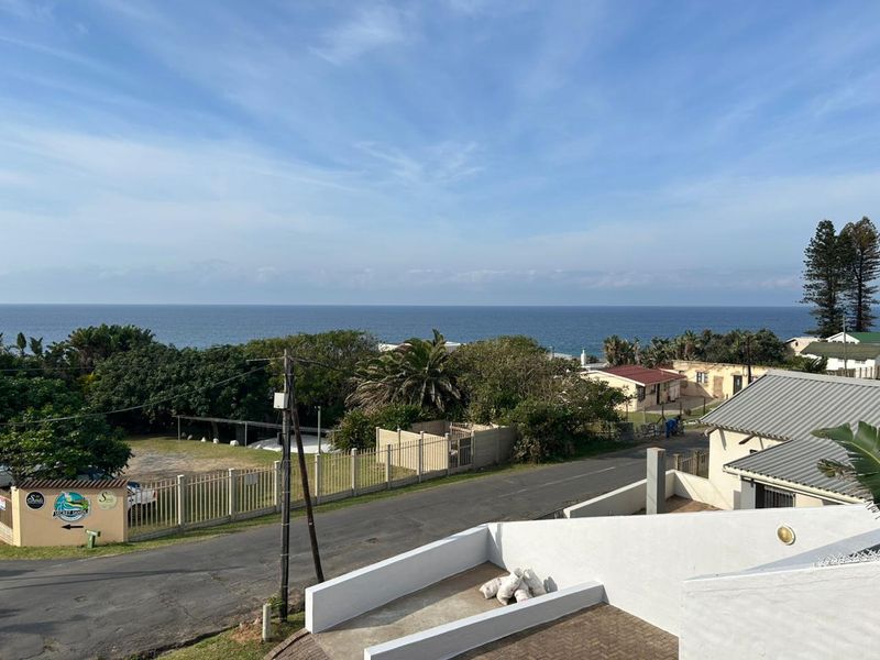 Elevated coastal view overlooking the street, surrounding neighborhood, and ocean horizon from the property.