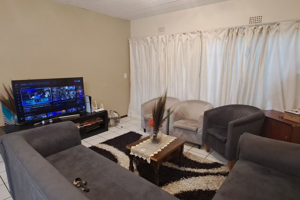 A functional living room featuring tiled flooring and neutral wall finishes, providing a comfortable space for relaxation and entertainment.