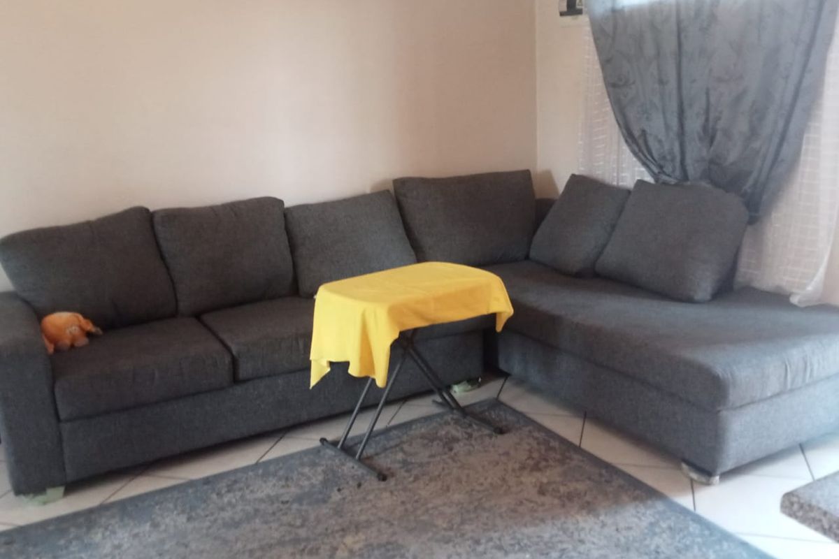 A living room area featuring tiled flooring and neutral wall finishes, providing a functional space for relaxation.