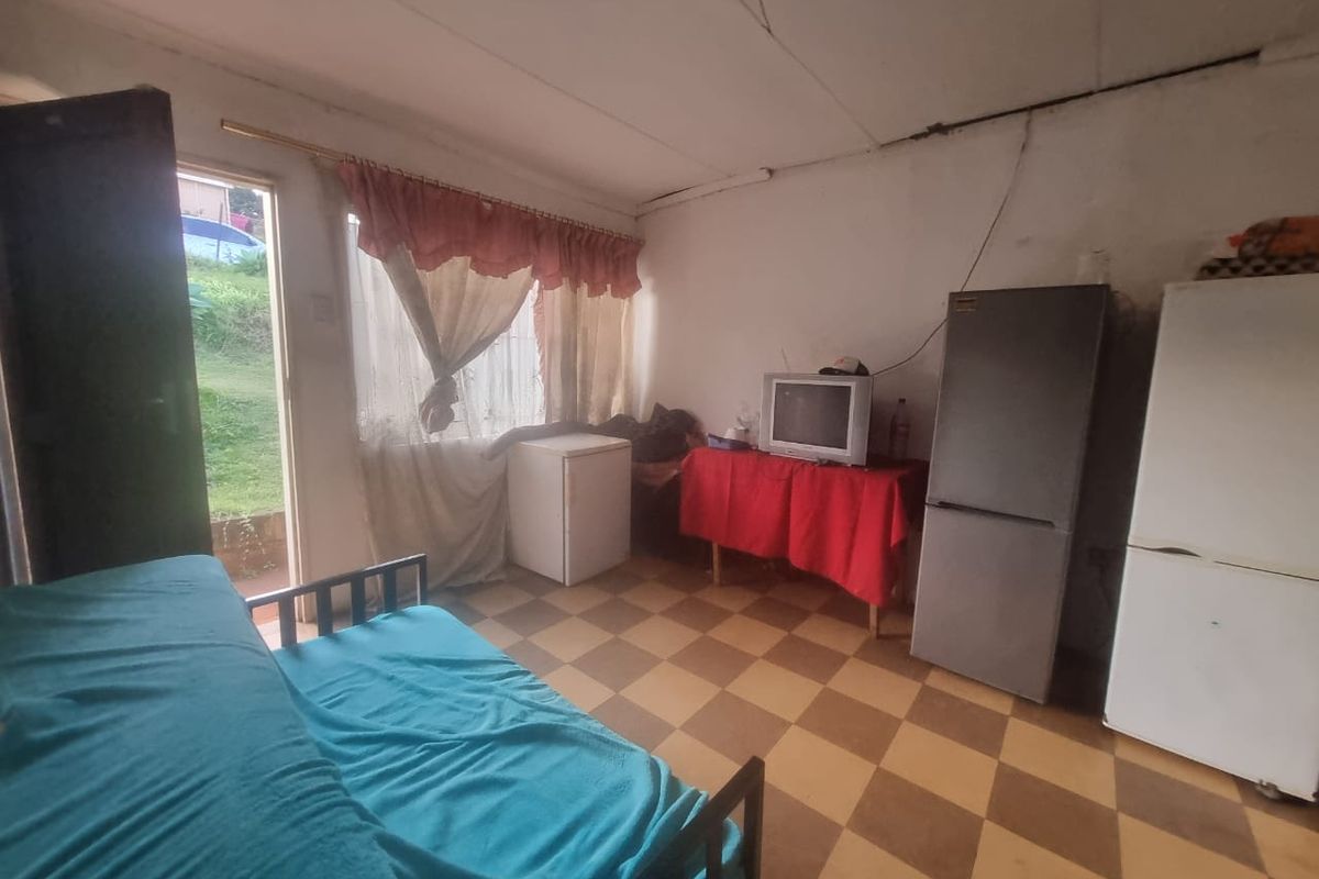 A living area featuring checkered floor tiles and direct access to the exterior, requiring cosmetic updates to improve the overall condition.