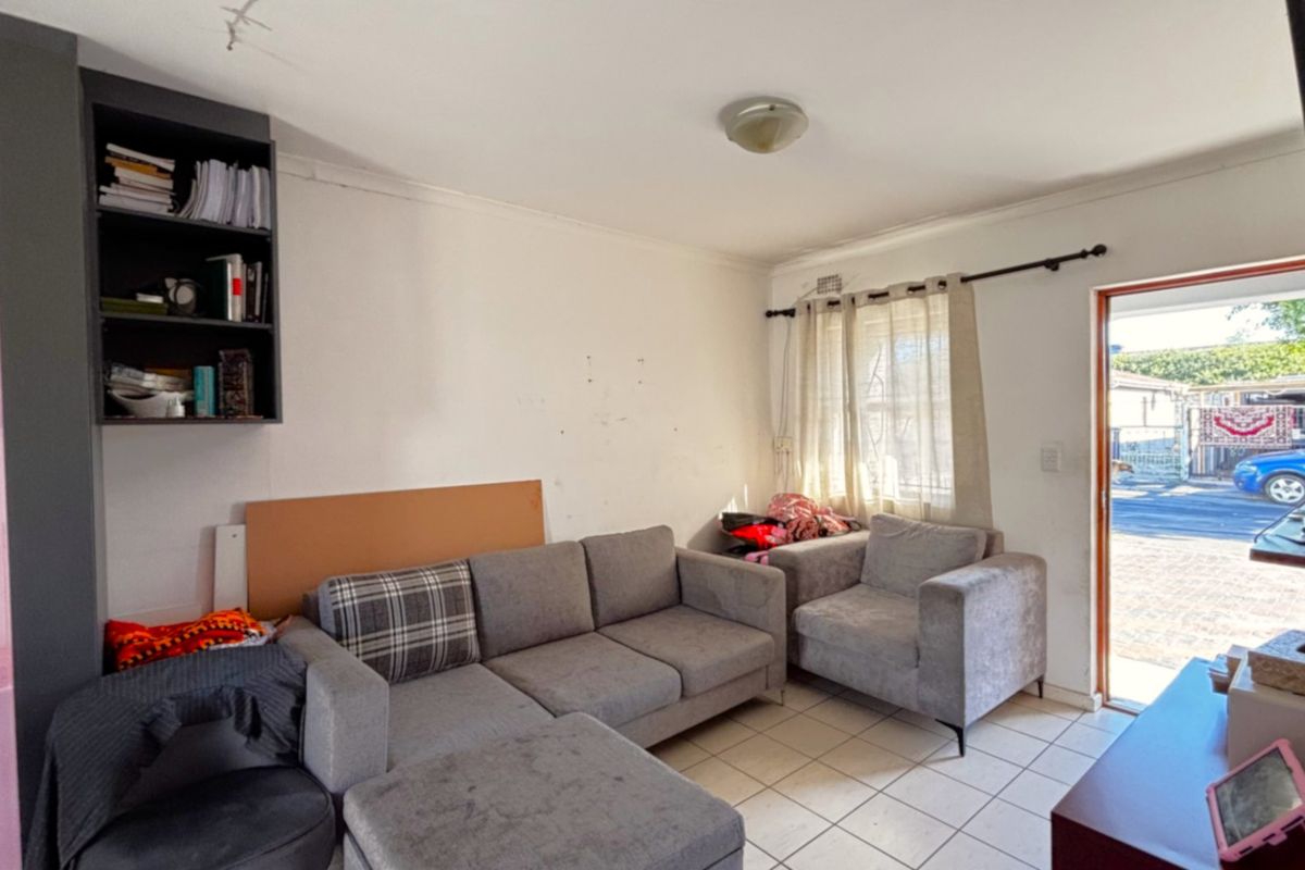 A living room area featuring tiled flooring and built-in shelving, with direct access to the exterior.