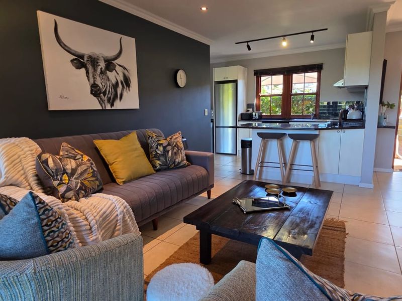 Open-plan living area featuring a modern kitchen with granite countertops, tiled flooring, and seamless flow to the outdoor patio area.