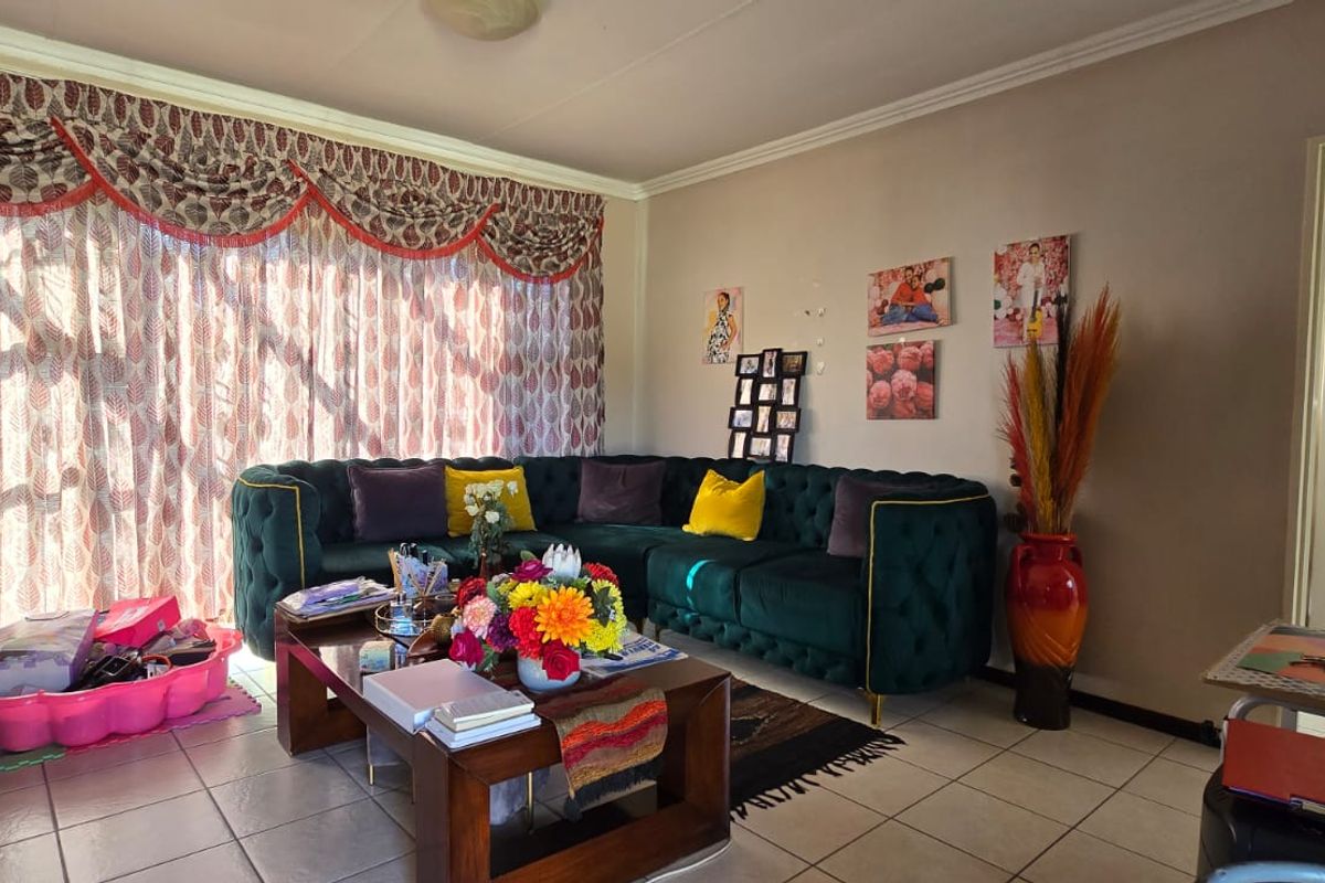 A comfortable living room featuring tiled flooring and coved ceiling details, offering a functional space for relaxation and family gatherings.