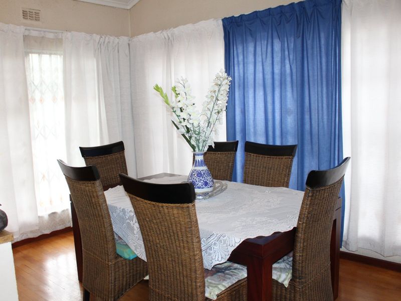 A dining room featuring hardwood flooring and corner detailing, providing a functional space for family meals.