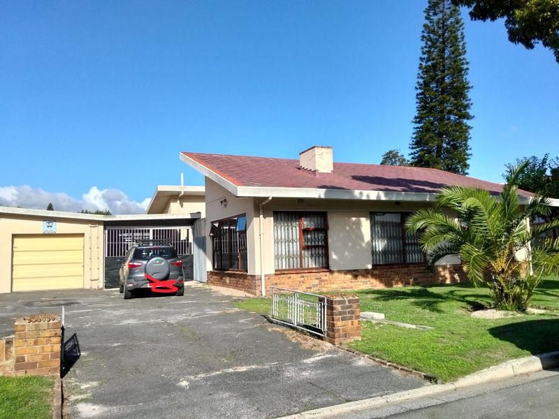 Front view of a single-story house featuring a tiled roof, brick base, attached garage, and security gates on windows.