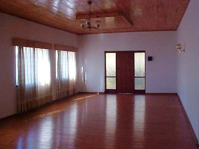 Spacious living area featuring polished timber flooring and a matching timber ceiling, providing a warm and classic foundation for your interior design.
