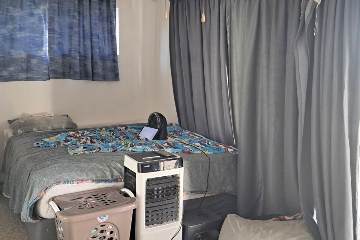 A bedroom featuring a ceiling fan and carpeted flooring, providing a functional space for rest.