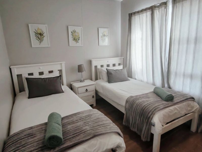 A well-maintained bedroom featuring laminate flooring and neutral wall tones, providing a comfortable and functional sleeping space.