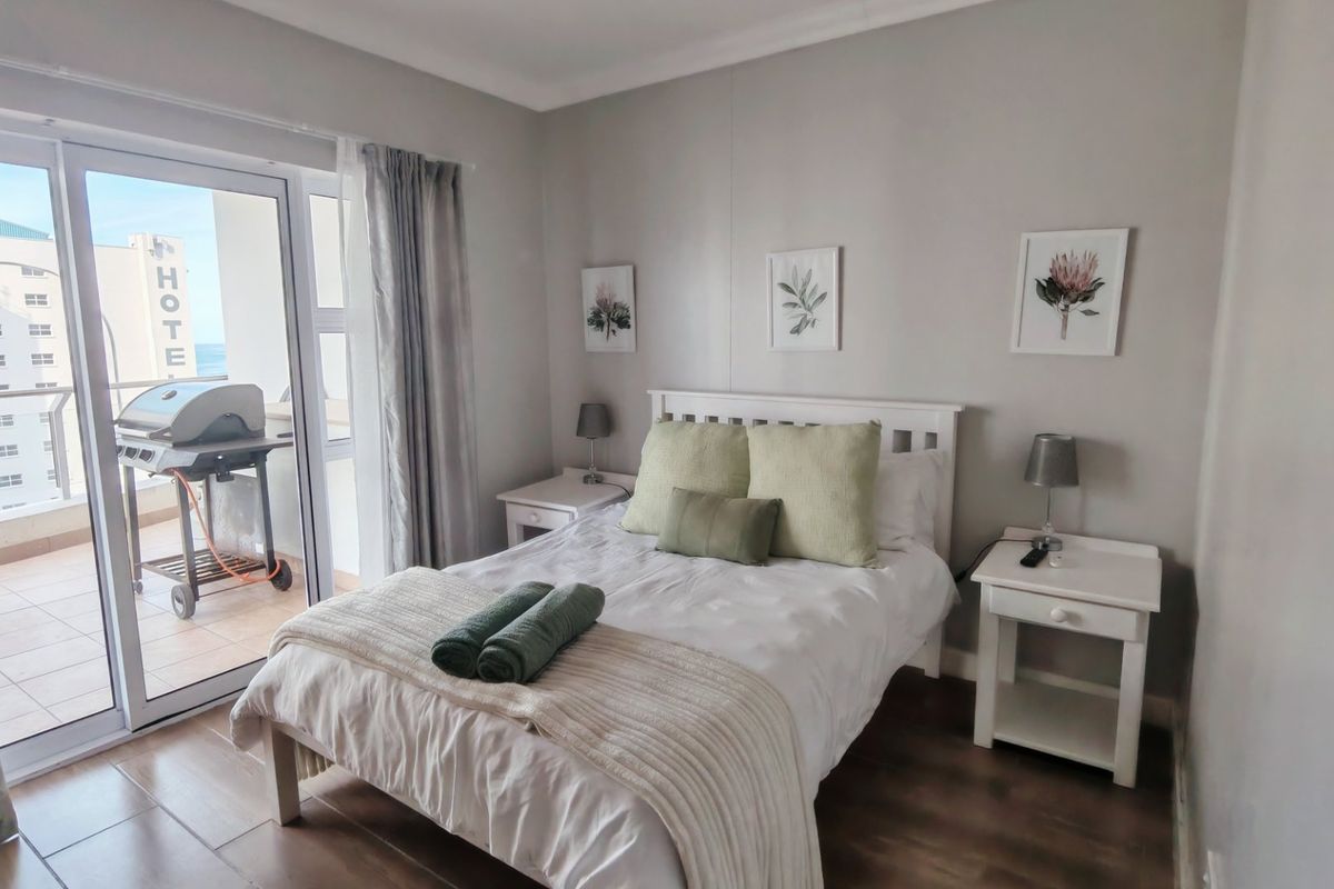 A well-maintained bedroom featuring tiled flooring and a sliding glass door providing access to a private balcony.