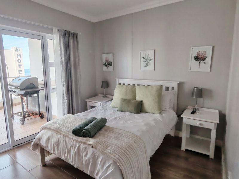 A well-maintained bedroom featuring tiled flooring and a sliding glass door providing access to a private balcony.