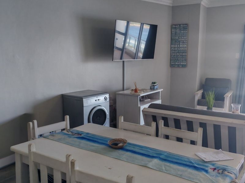 Open plan living and dining area featuring tiled flooring, coving, and direct access to a balcony through a sliding door.