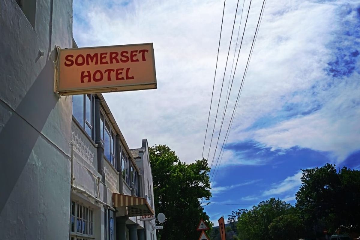 Street-level view of the Somerset Hotel facade, featuring traditional multi-pane windows, building signage, and an adjacent public sidewalk.