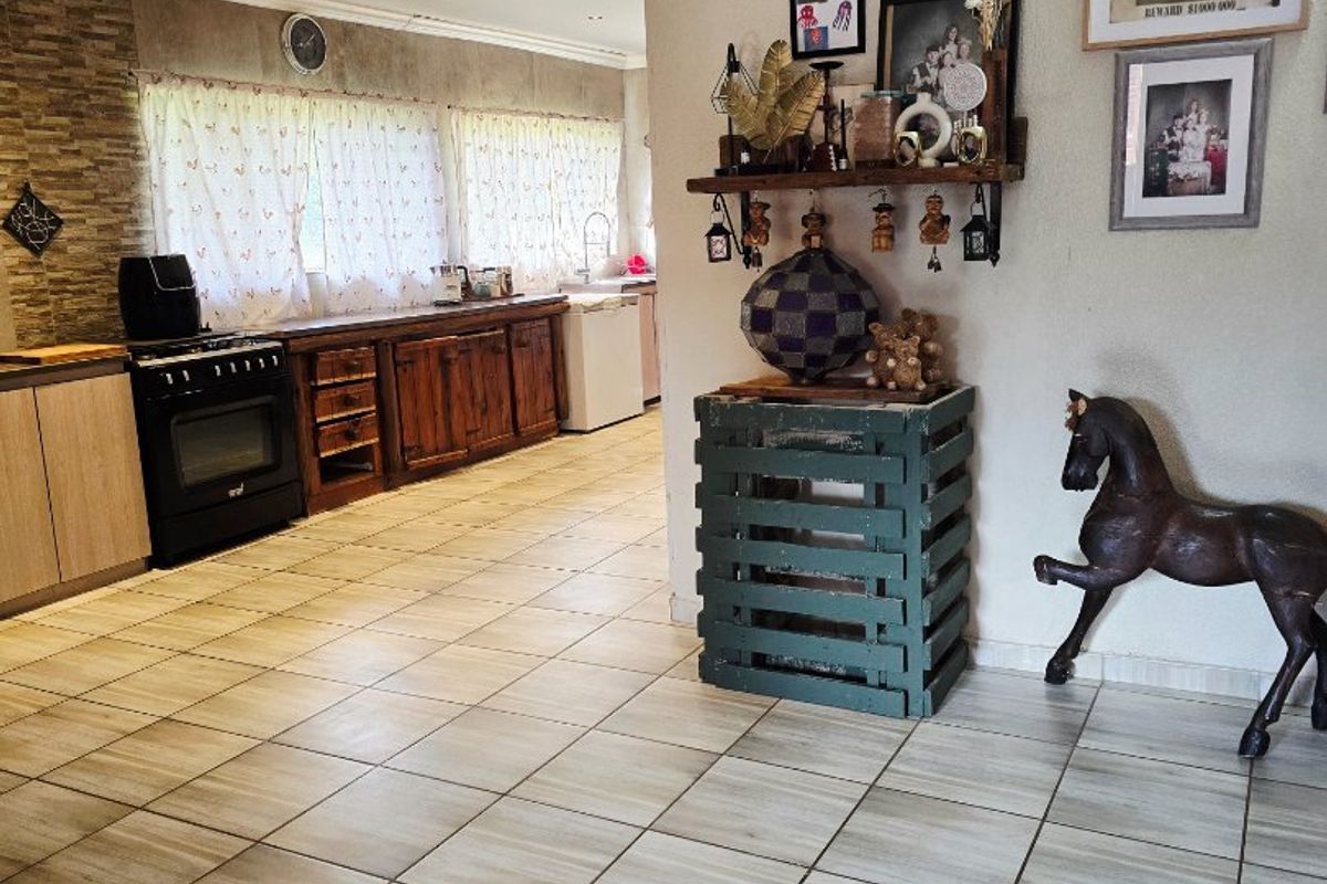 Spacious kitchen featuring tiled flooring, stone-cladding backsplash, and wooden cabinetry, offering a functional layout with recessed lighting.