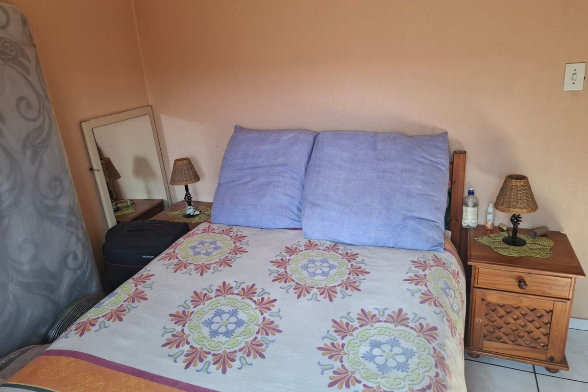 A bedroom featuring tiled flooring and neutral wall finishes, providing a functional space for rest.