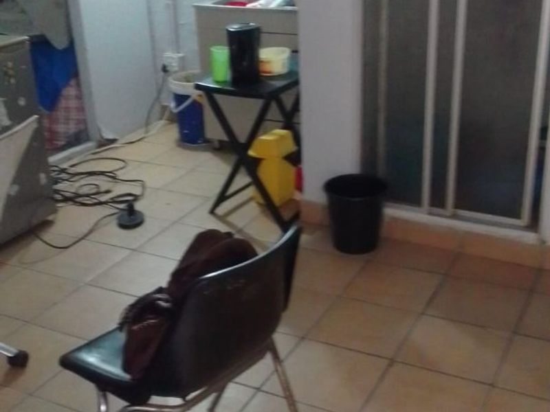 A utility or multi-purpose space featuring tiled flooring and a sliding glass door, currently used for storage and general utility purposes.
