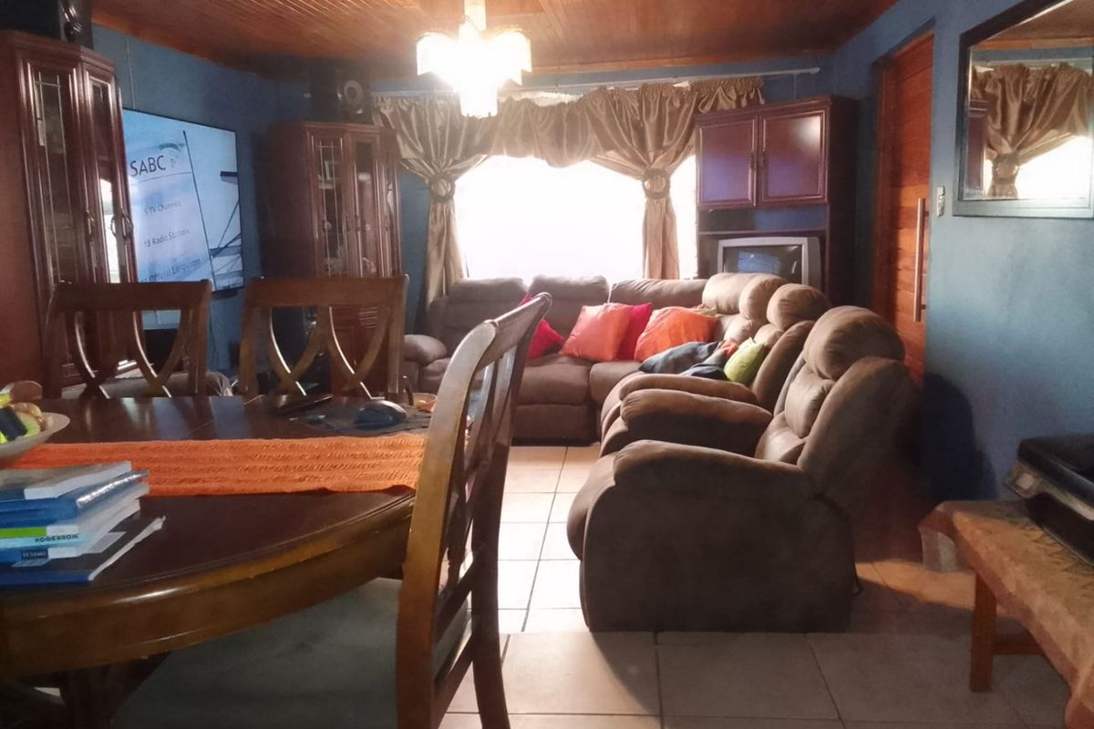 A living room featuring ceramic floor tiles and a timber tongue and groove ceiling, providing a traditional aesthetic.