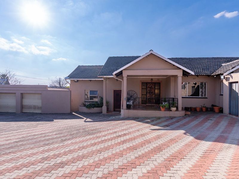 Front elevation of a single-story house featuring a paved driveway, double garage, and a covered entrance porch with security features.