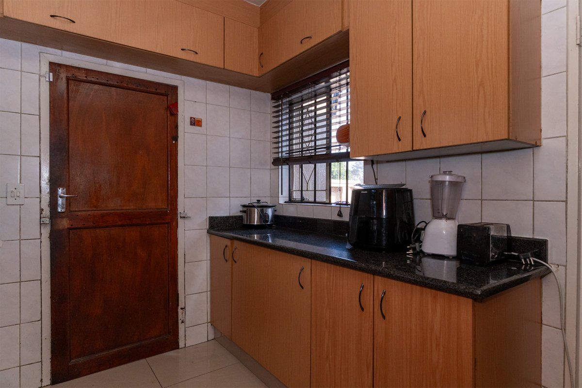 A functional kitchen featuring laminate cabinetry, granite countertops, and tiled backsplash, offering a practical workspace with a classic layout.