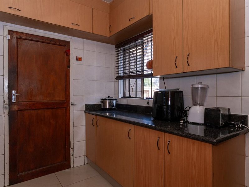 A functional kitchen featuring laminate cabinetry, granite countertops, and tiled backsplash, offering a practical workspace with a classic layout.