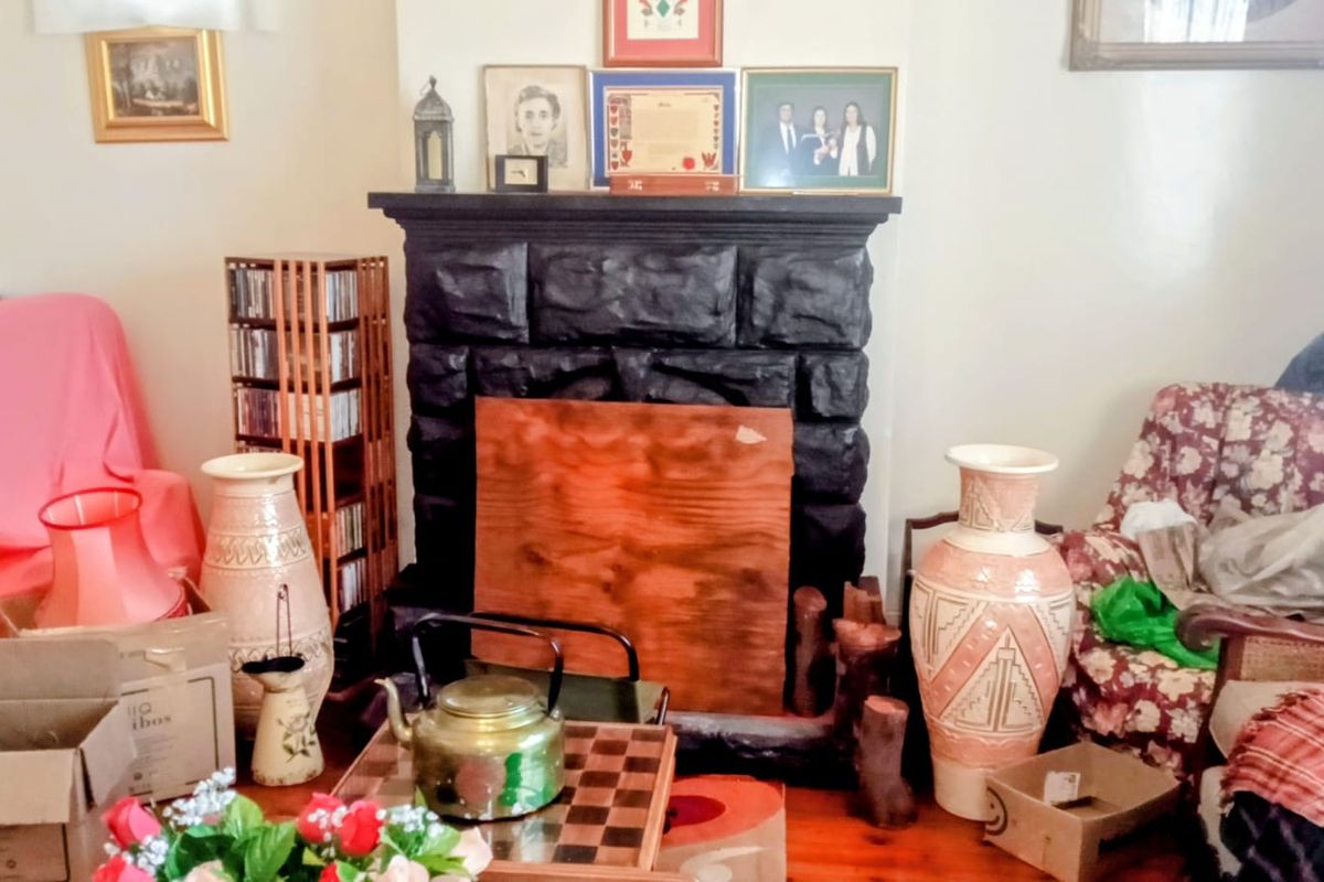 Living room featuring a prominent fireplace with timber flooring, offering a traditional layout ready for modernization and cosmetic updates.