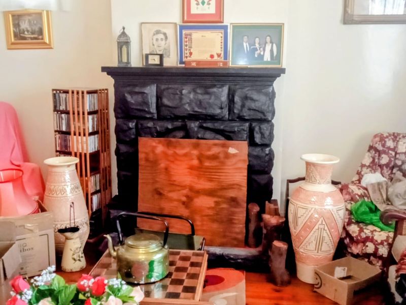 Living room featuring a prominent fireplace with timber flooring, offering a traditional layout ready for modernization and cosmetic updates.