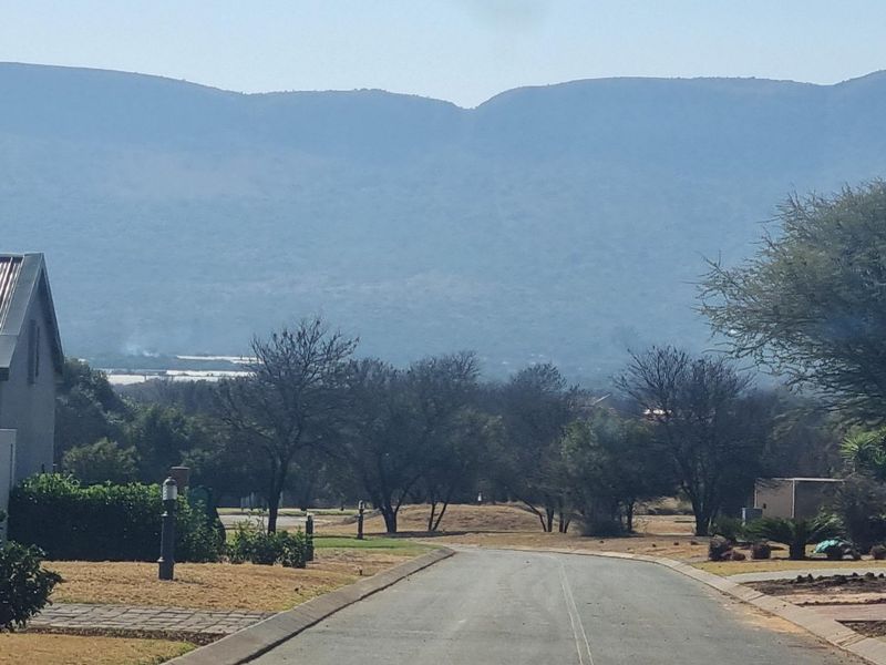 A view of the residential street approach featuring paved roads and scenic mountain views in the background.