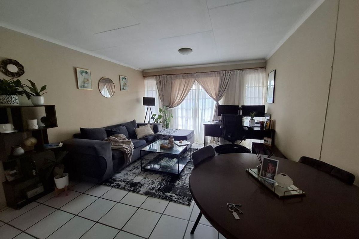 Open plan living and dining area featuring tiled flooring and a sliding glass door leading to the exterior.