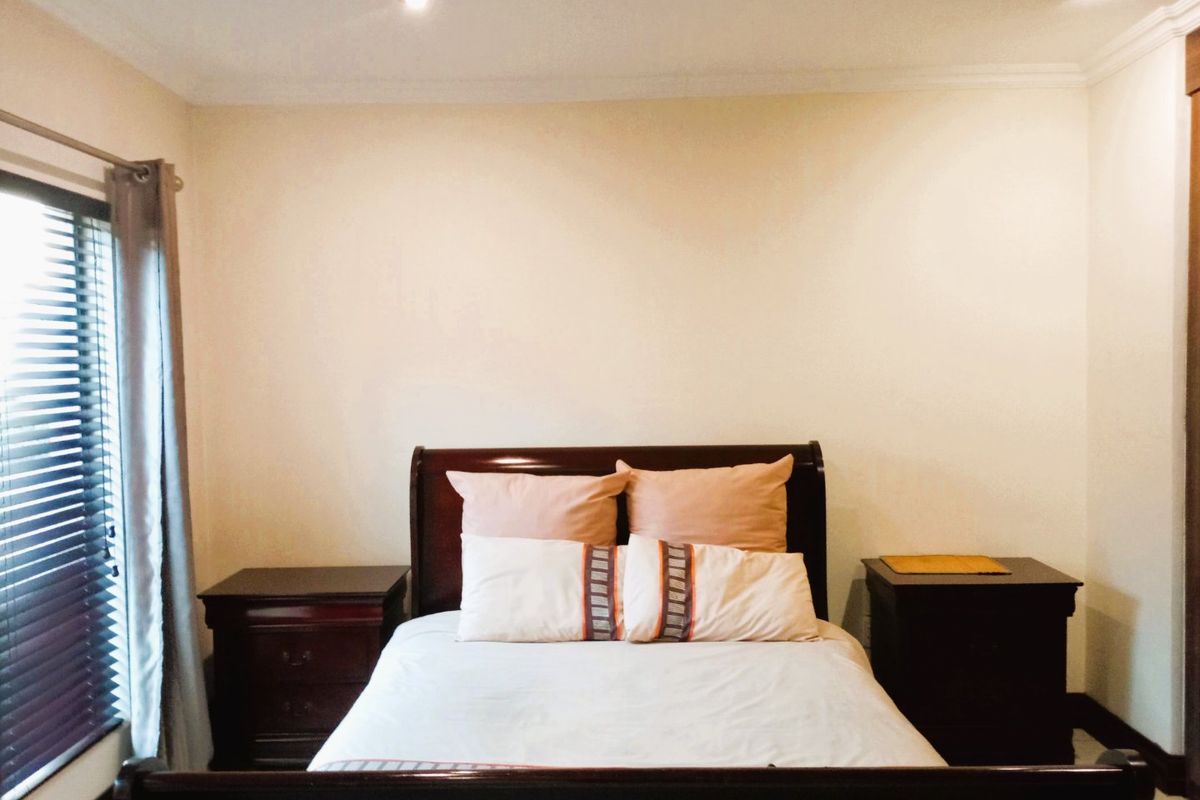 A well-maintained bedroom featuring recessed downlighting, coving, and venetian blinds, providing a neutral and functional space.