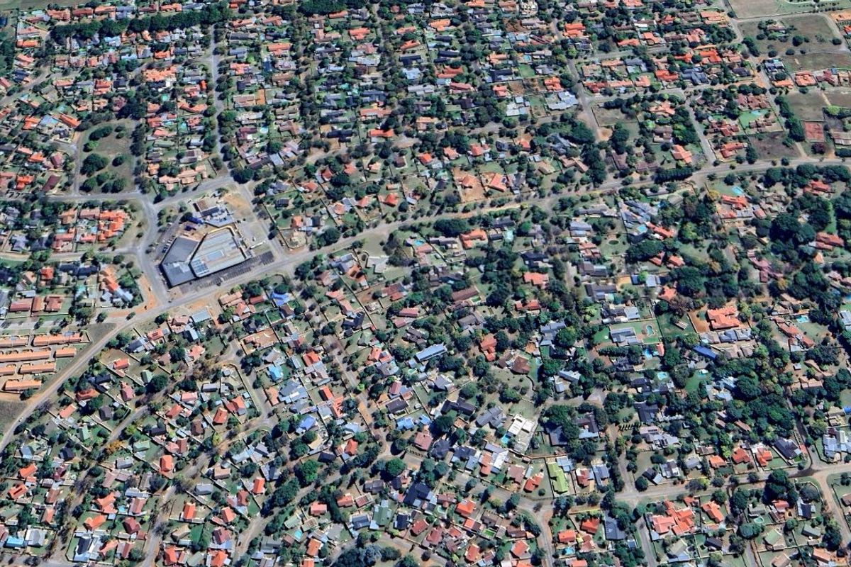 An aerial view of a residential neighborhood showing the layout of houses, streets, and surrounding vegetation.