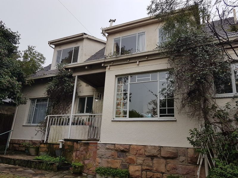 Front elevation of a two-story house featuring stone cladding, stucco finish, and a covered porch entrance with metal railing.
