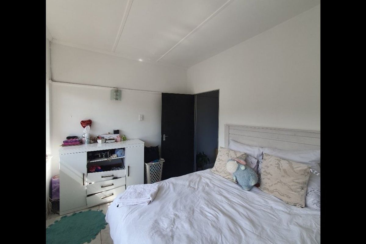 A standard bedroom featuring tiled flooring and a neutral interior finish, providing a functional space for rest.