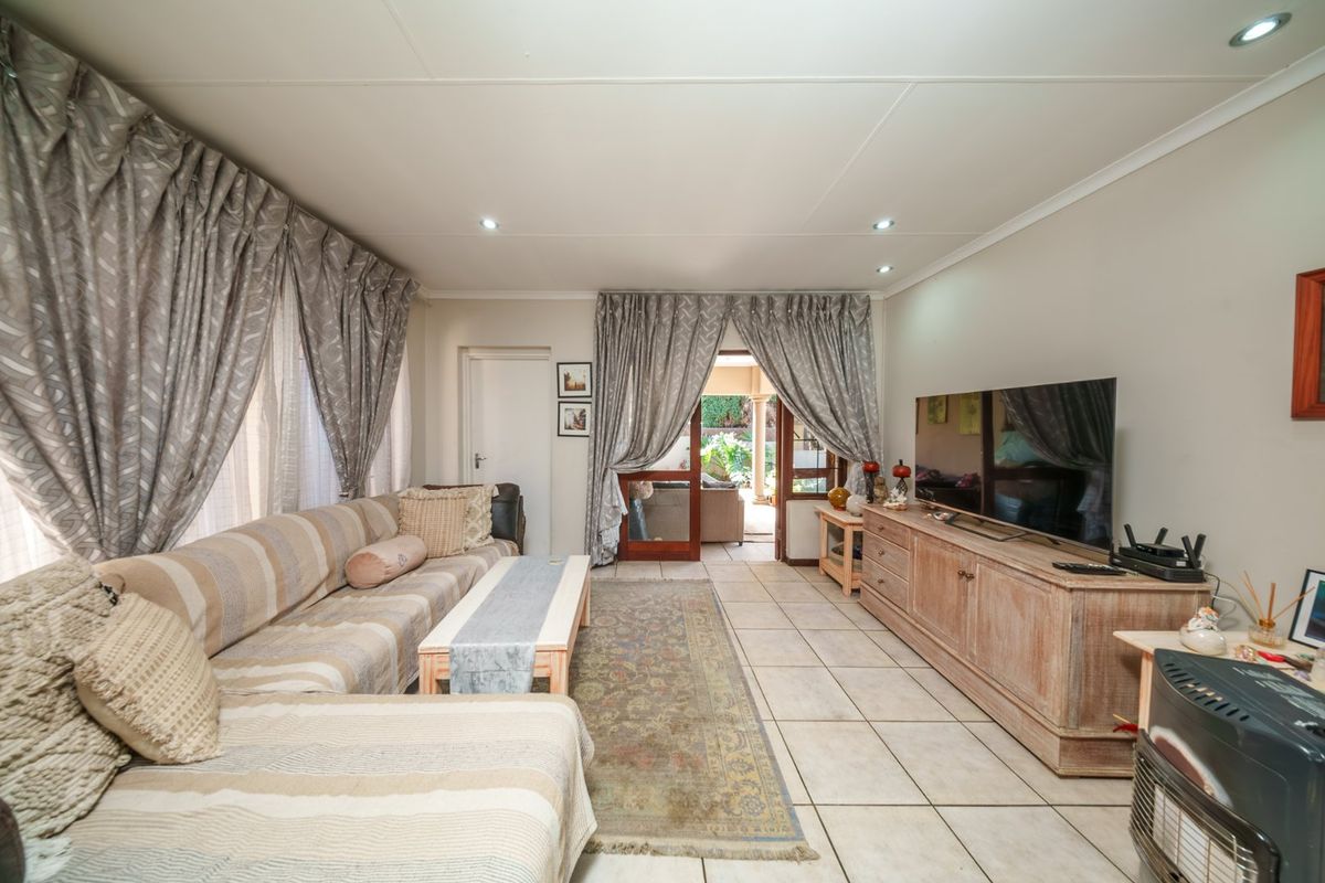 Spacious living room featuring tiled flooring, recessed downlighting, and direct access to an outdoor patio area through sliding glass doors.