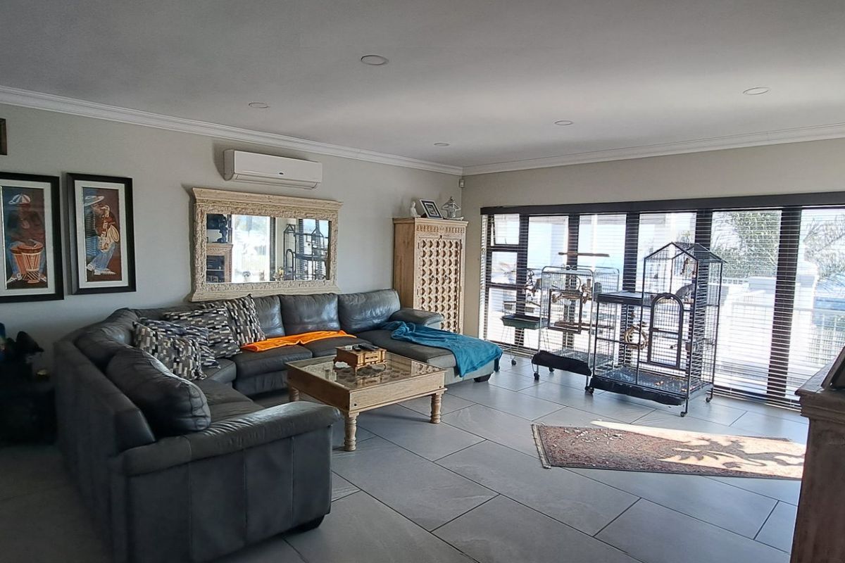 Spacious living room featuring large format floor tiles, recessed downlighting, and wide sliding glass doors providing ample natural light and access to the exterior.