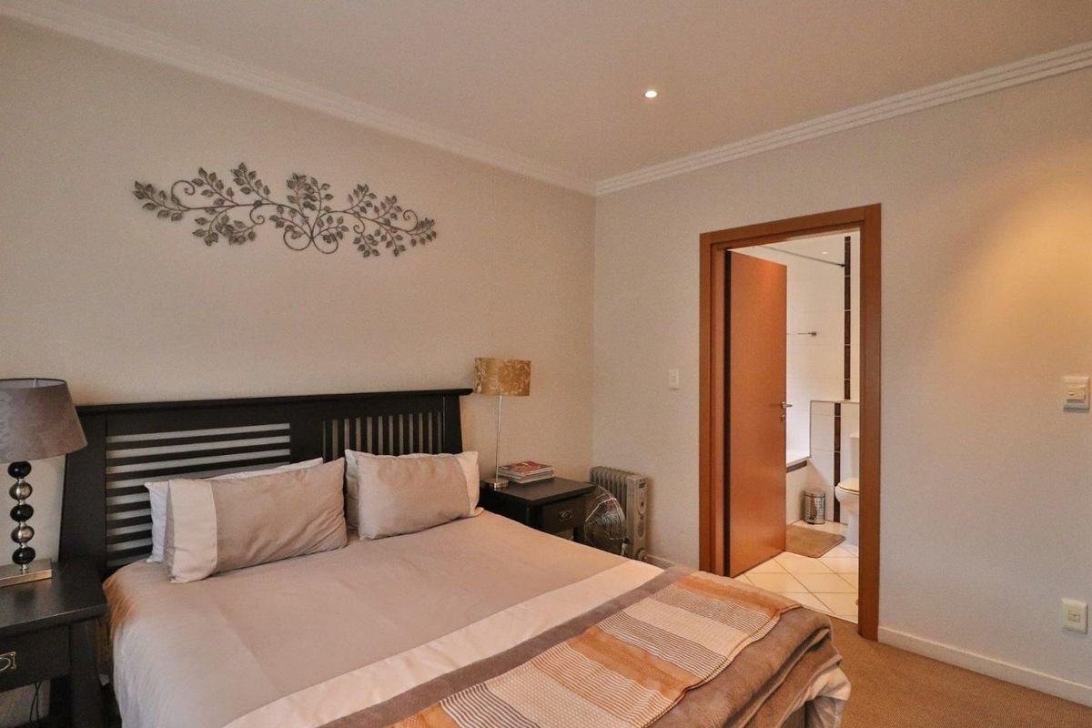A well-maintained bedroom featuring neutral walls, coving, recessed lighting, and direct access to an en-suite bathroom.